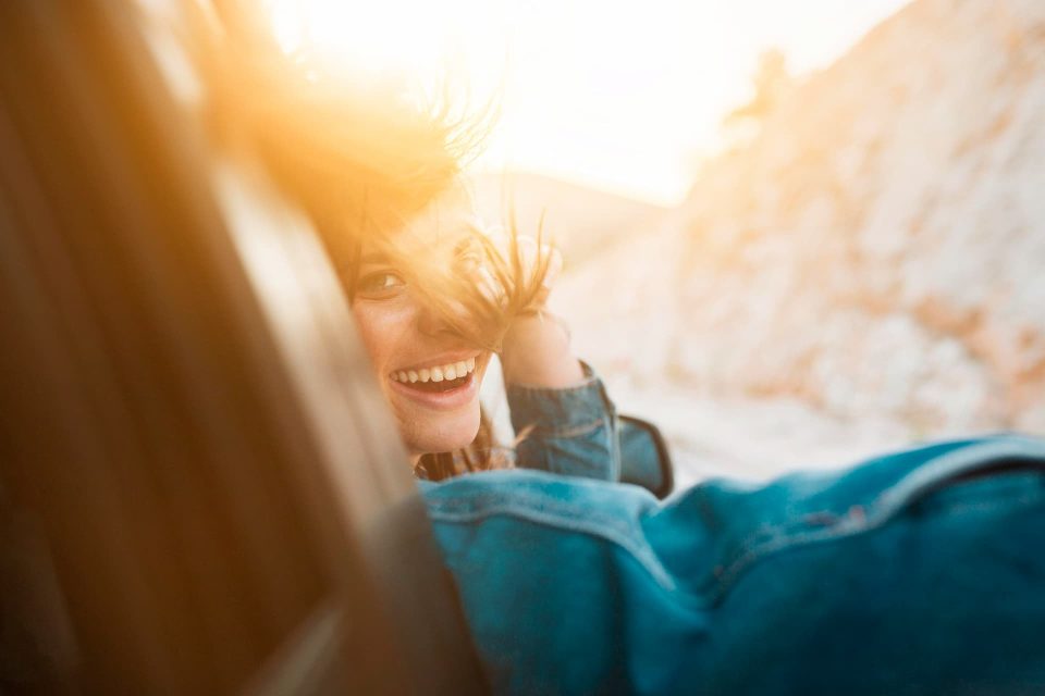 woman smiling while being in a car ride